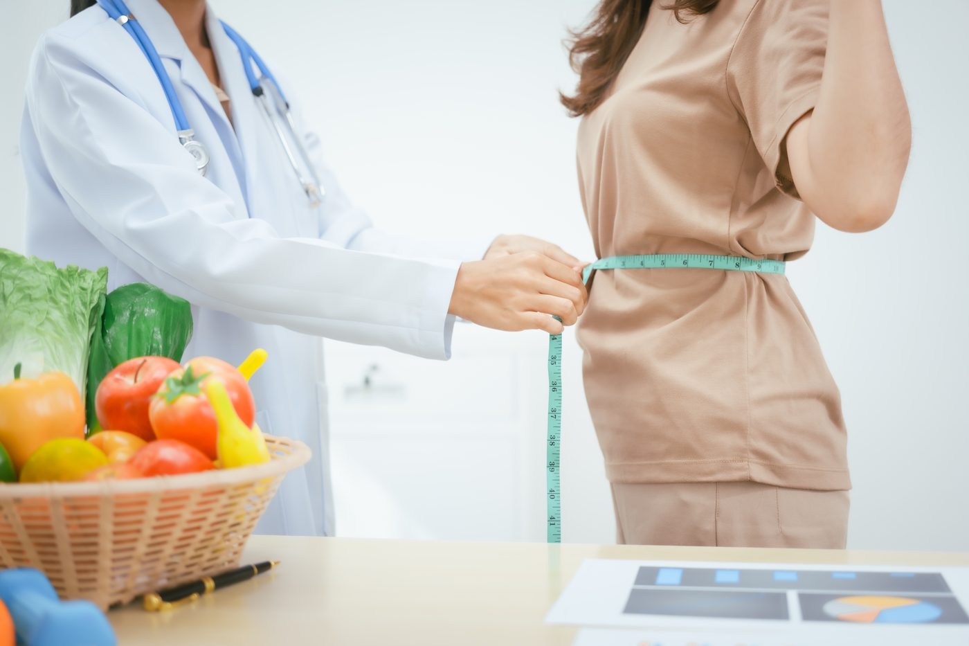 Consulta nutricional con medición corporal y alimentos saludables